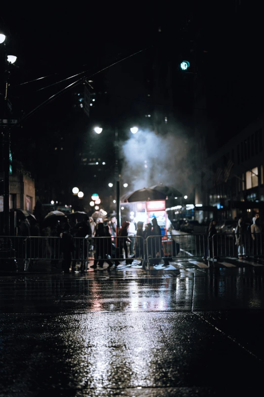 the people are on the sidewalk in the rain