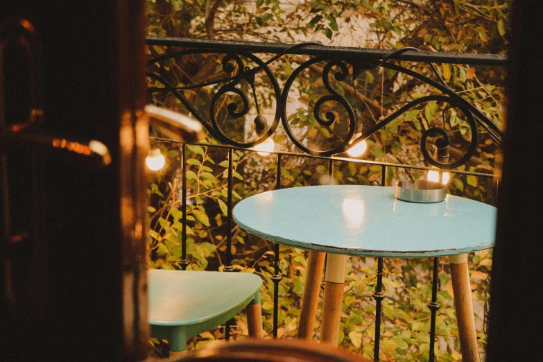 a table on a balcony overlooking a green tree