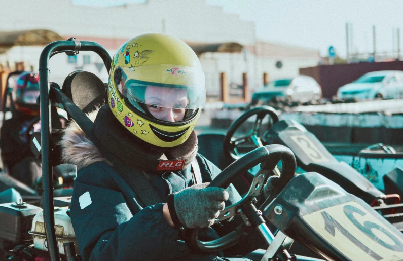 a man in yellow helmet sitting in a go - cart