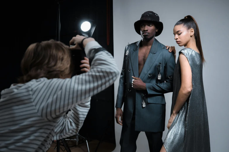 a man is standing behind two women in a studio