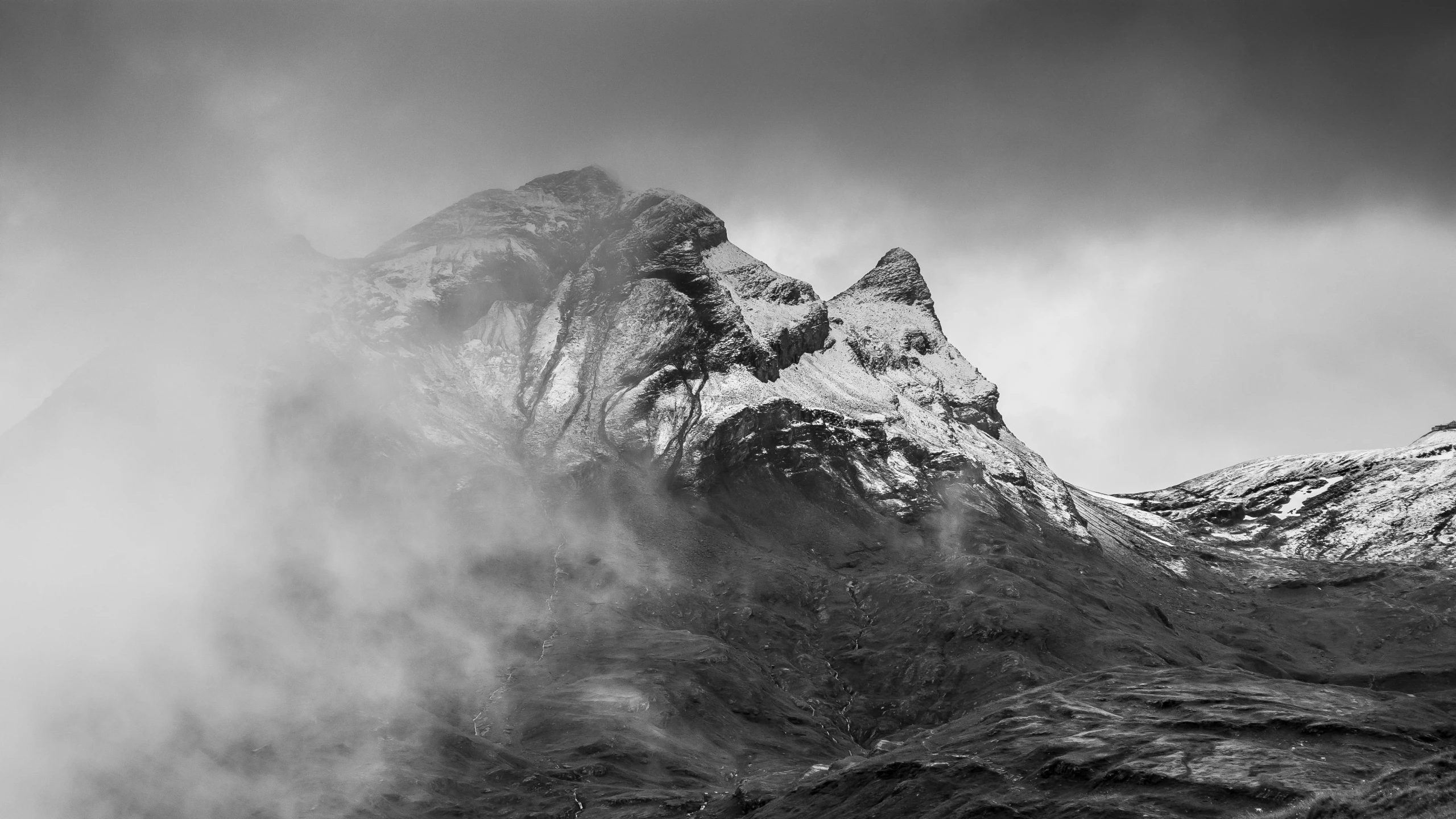 a mountain rising up from a cloud covered mountain