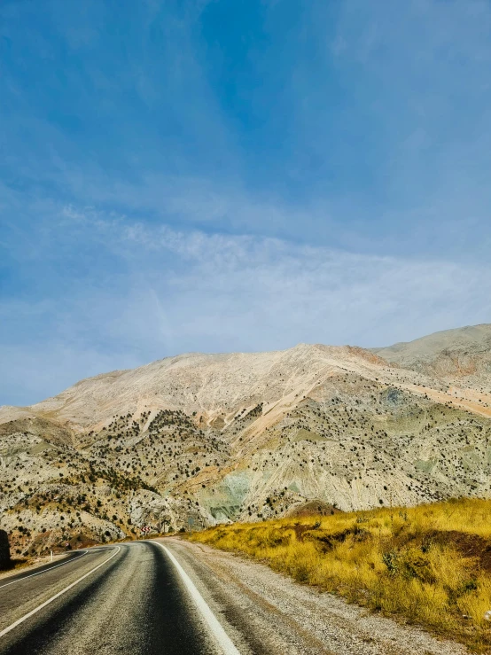 the road is winding and clear as it passes through the mountain