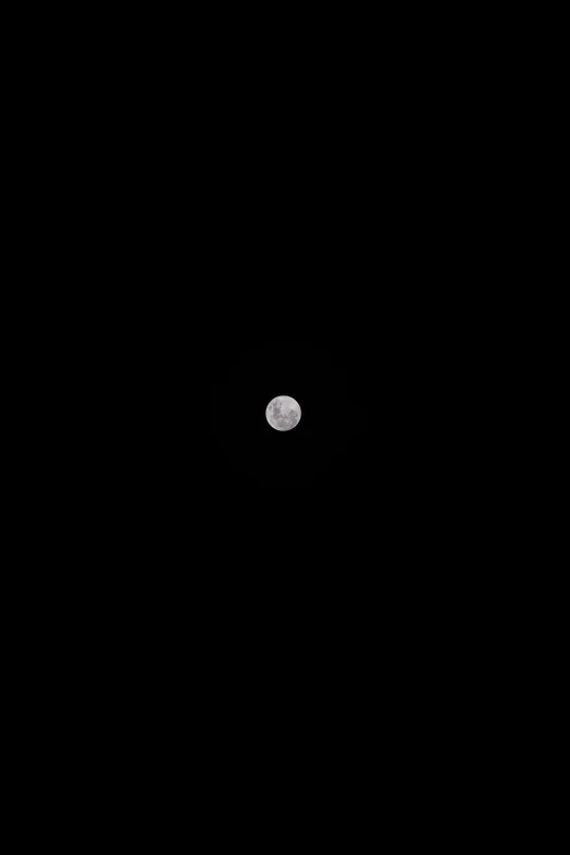 the full moon is seen through a black sky