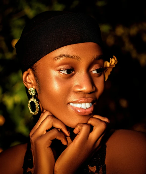 the woman is wearing a black top and gold earrings