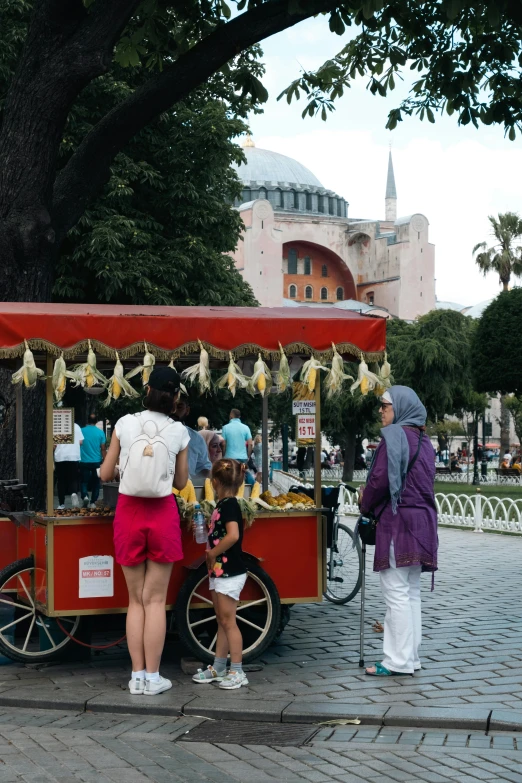 a man and woman standing in front of a cart selling fruit