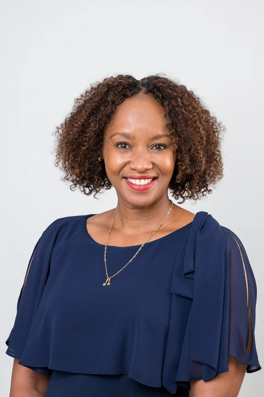 an african woman smiling and wearing a blue blouse