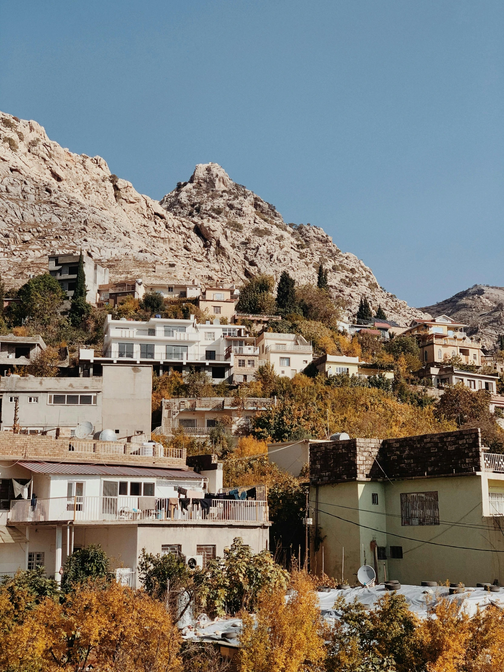 this po shows houses on a hillside with mountains in the background