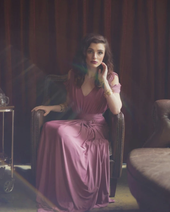 a woman sitting in a chair while talking on a cell phone