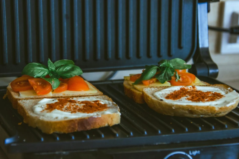 two slices of bread topped with cream and tomatoes