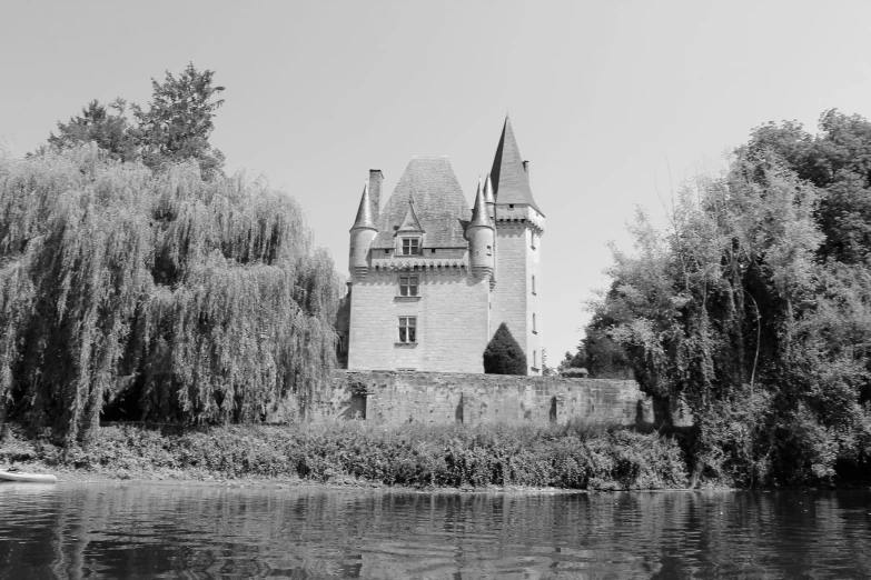 a castle near a river with trees around