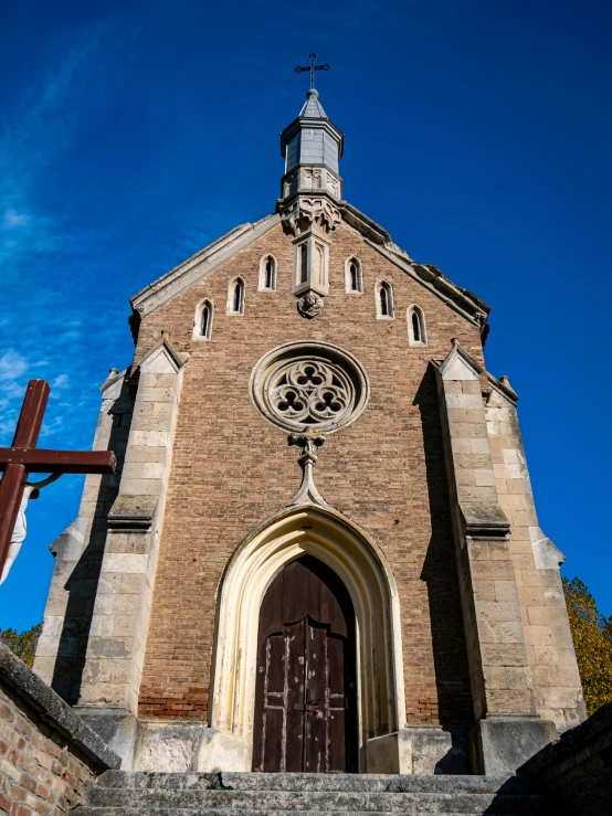 a tall brick church with a cross on the door