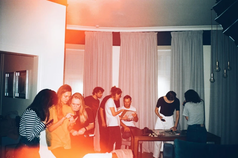 people standing around in a living room with curtains