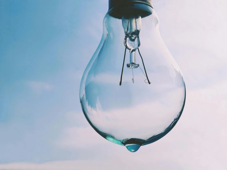 a glass light bulb with a clock at the top of it