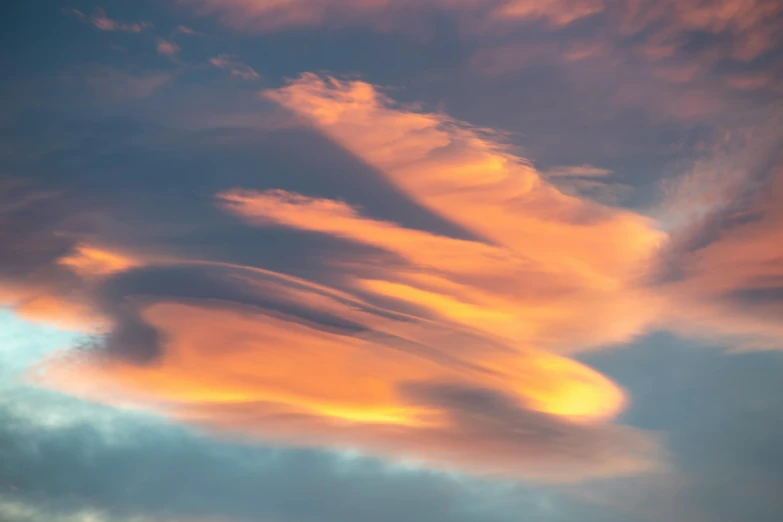 pink clouds and blue sky with a plane flying low