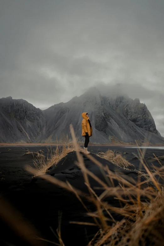 the lone person standing on the rock is looking into the distance