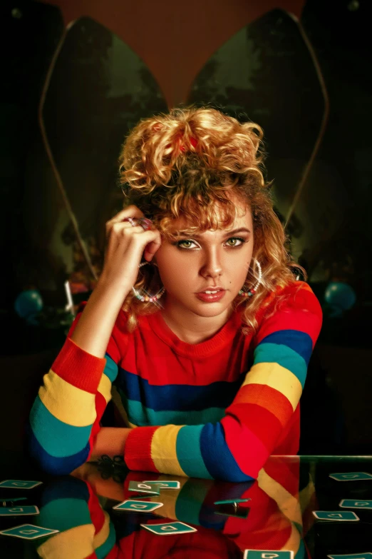 a very pretty woman wearing colorful clothes sitting by a table