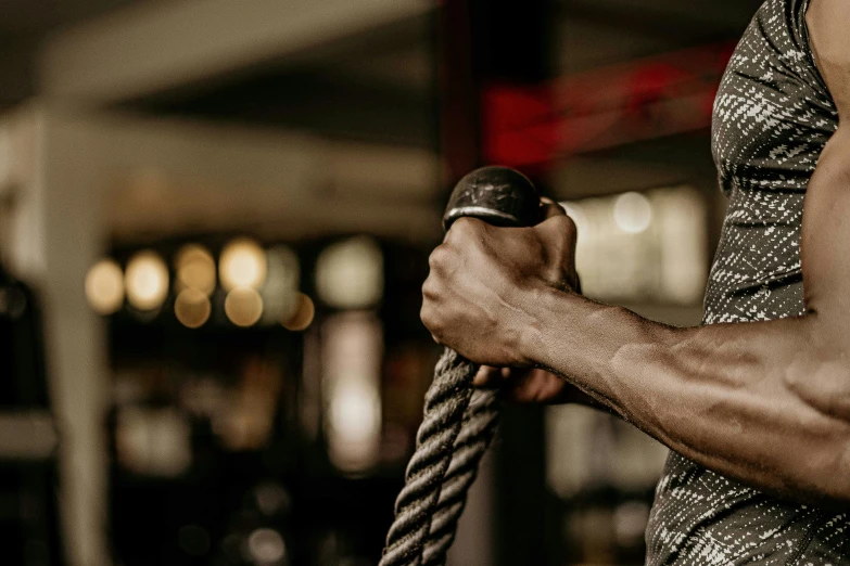 the woman is holding on to the rope in the gym