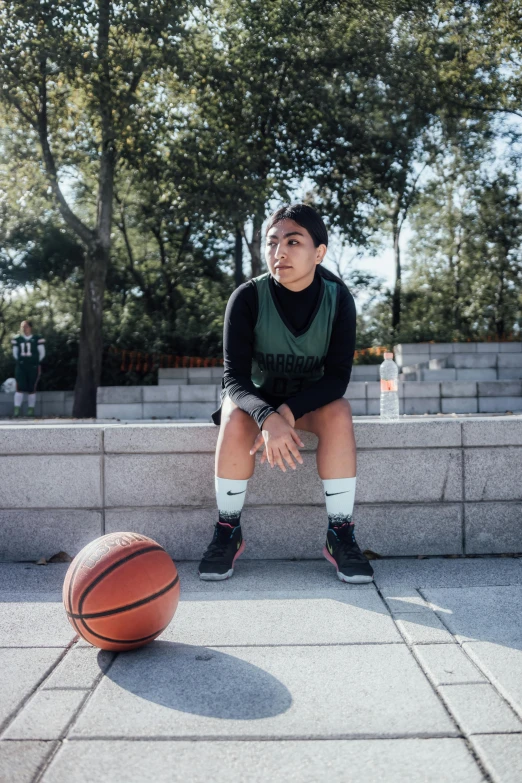 a woman posing by a basketball ball for the camera