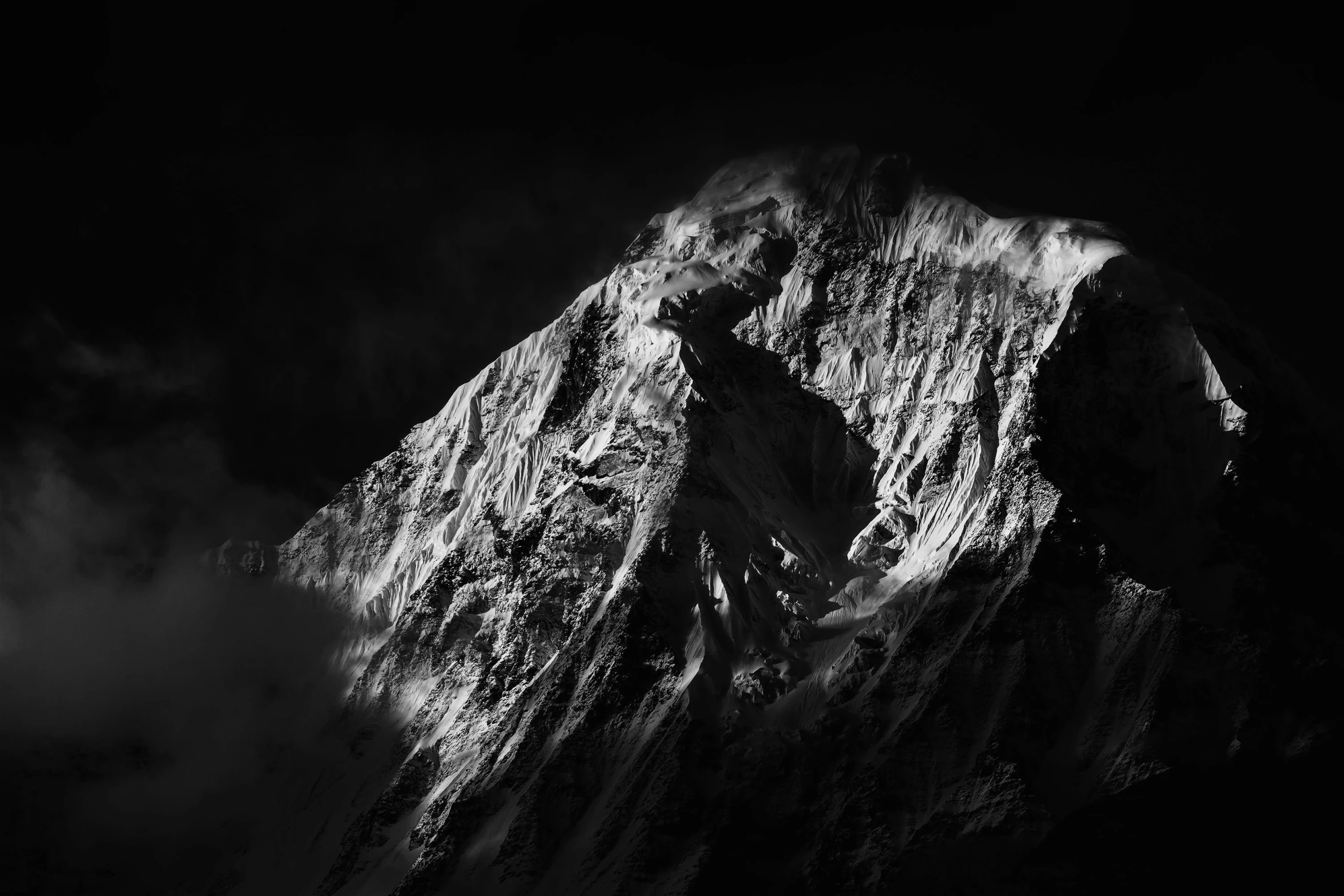 a mountain in the dark with clouds and a moon