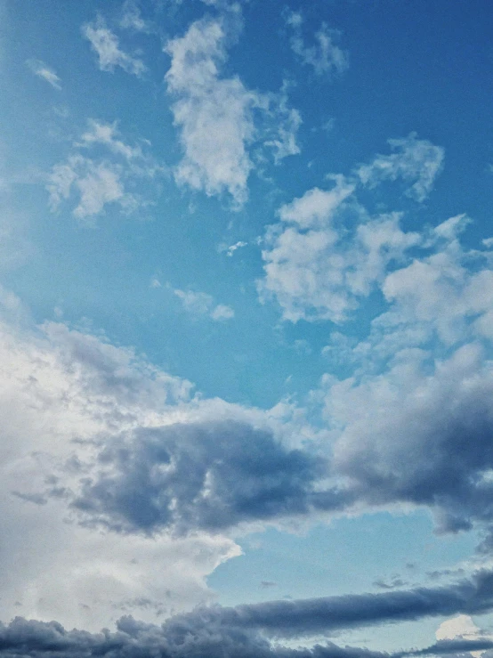 a person on the ocean with a surfboard under a cloudy blue sky