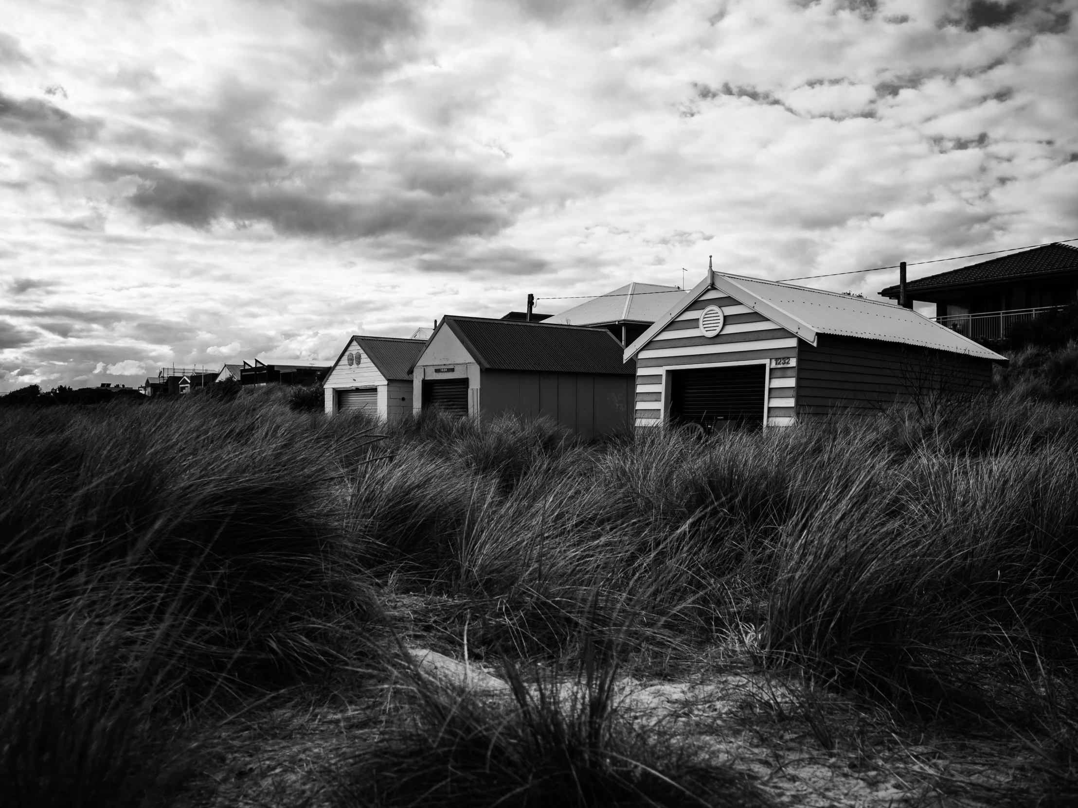 a house with some grass around it near a cloudy sky