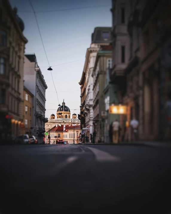 a street view looking down a street with a church tower on top