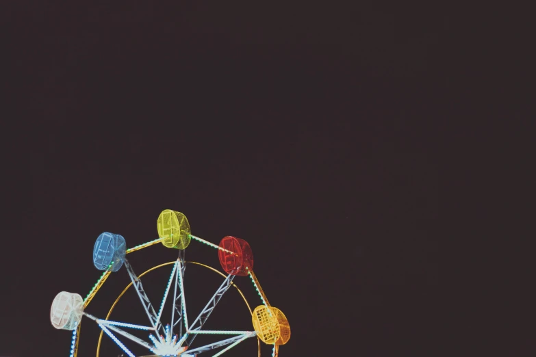 the ferris wheel is brightly lit against the night sky