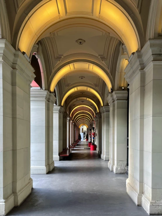 a white hallway with pillars and some lights on it