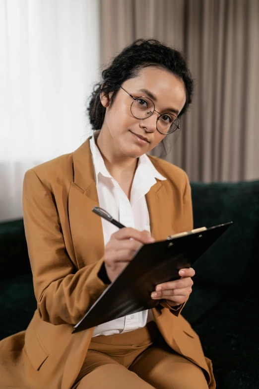 a woman is sitting on a couch with glasses on