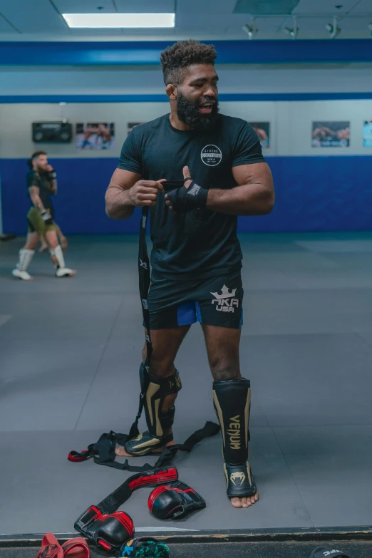 a man stands near an assortment of roller blades