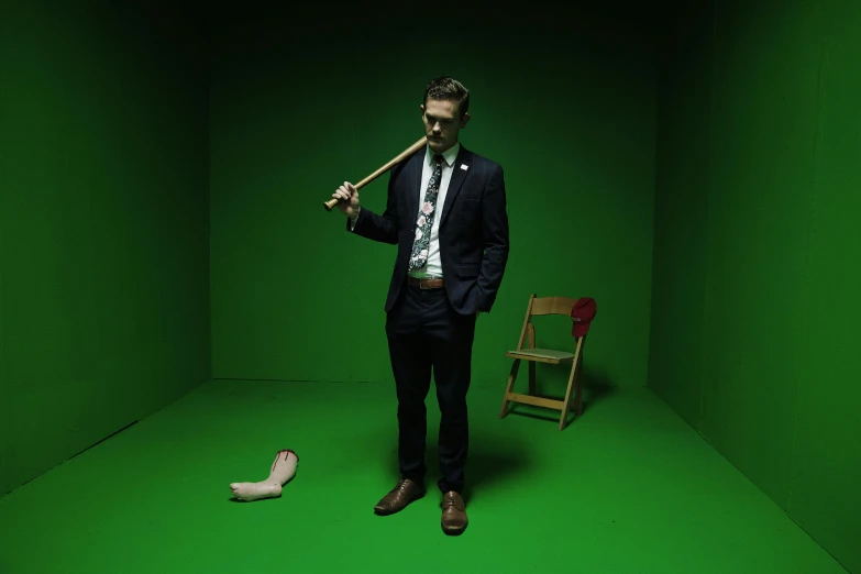 a man poses for the camera holding a bat