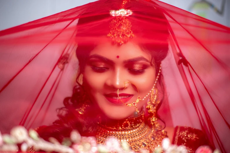 a woman standing under a red veil