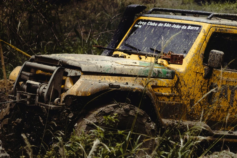 a mud covered jeep drives through a field