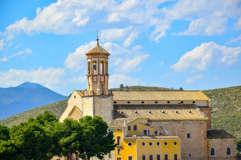 a church with a large tower and mountains in the background