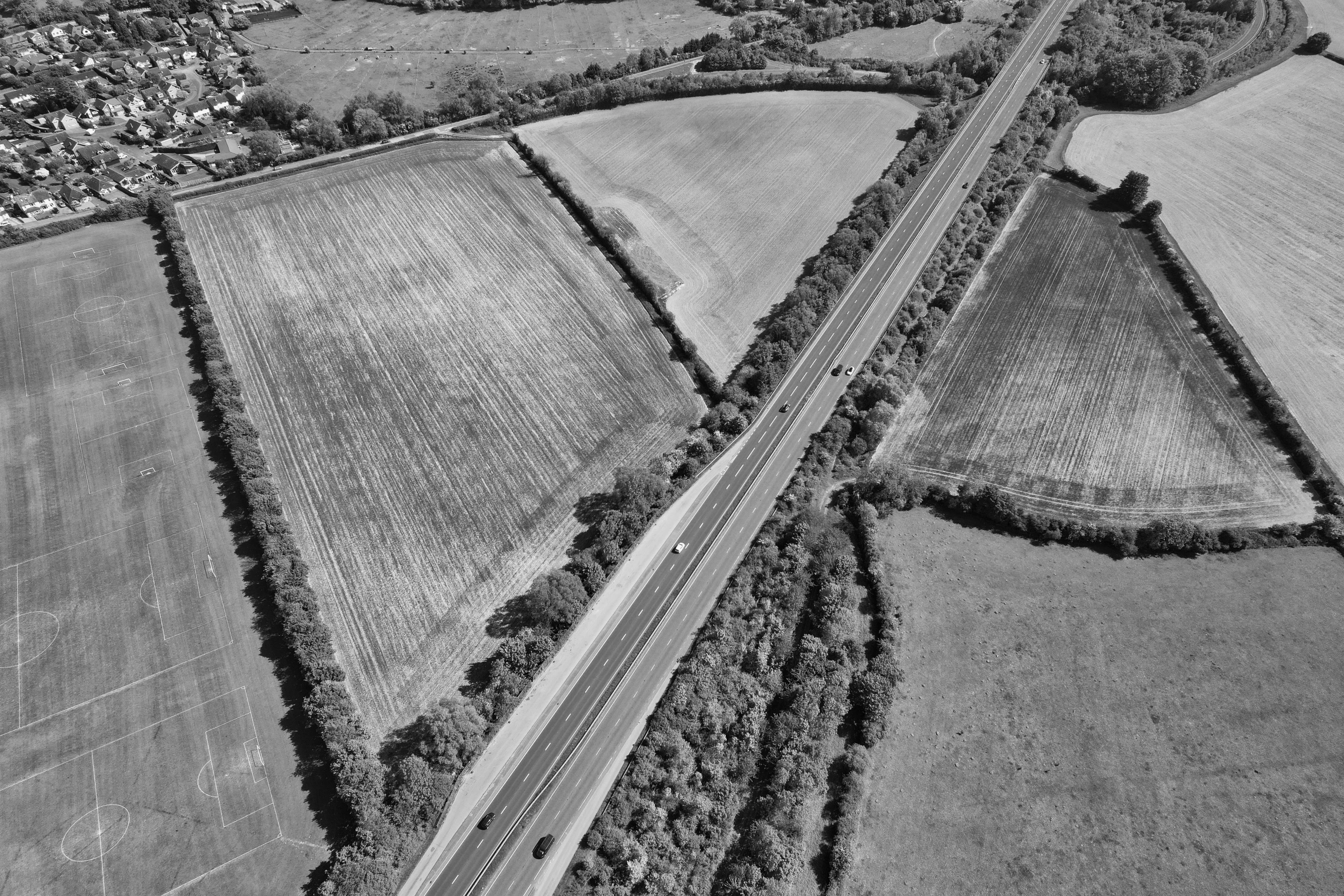 an aerial view of a highway through some farmland