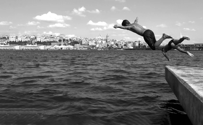 a man diving into the water from a pier