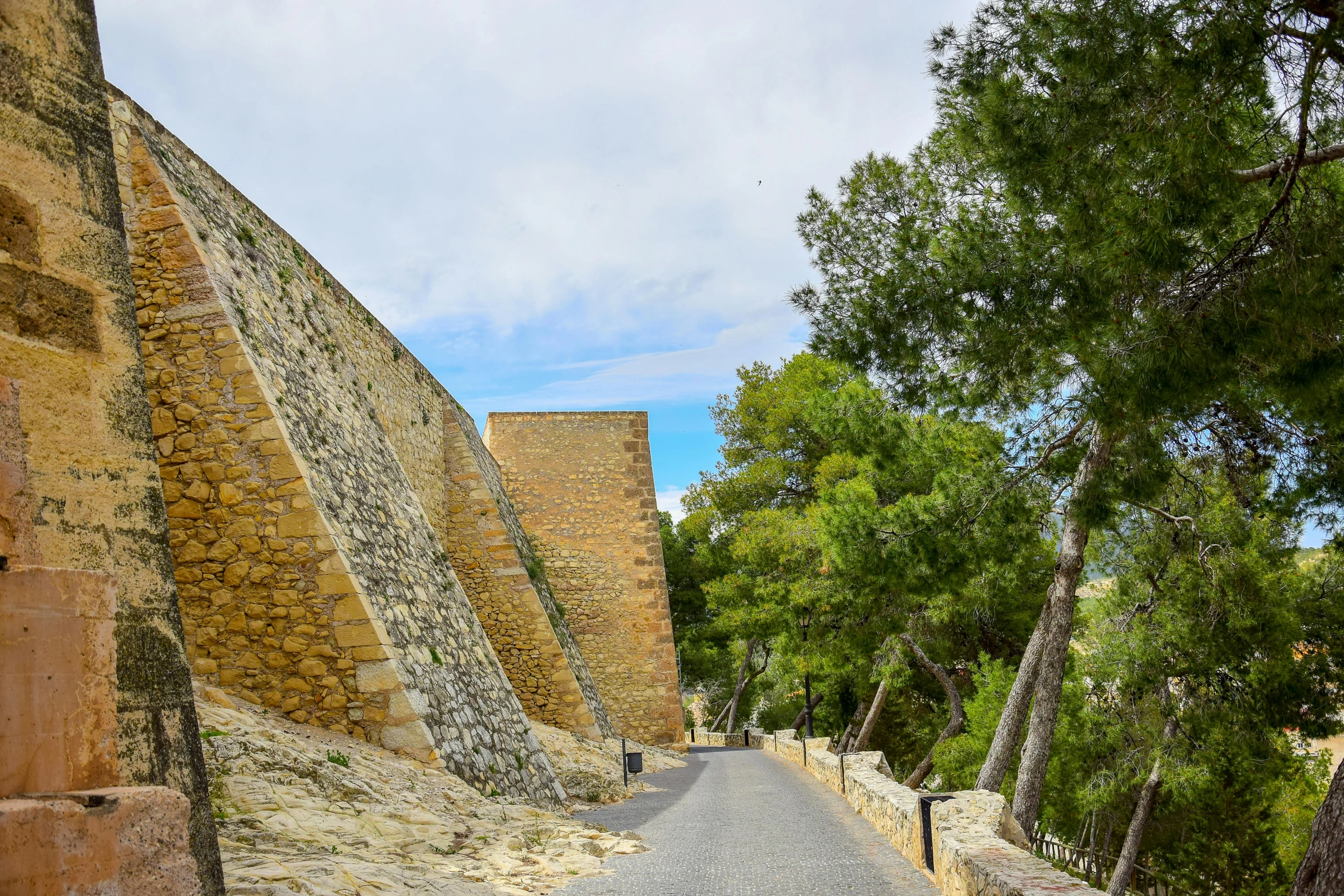 a paved road is in between the two large walls