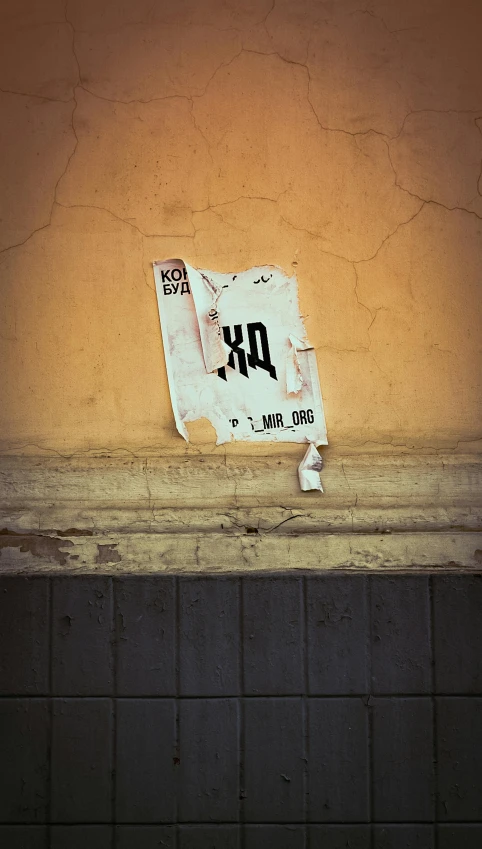 a cardboard sign hanging on a building wall