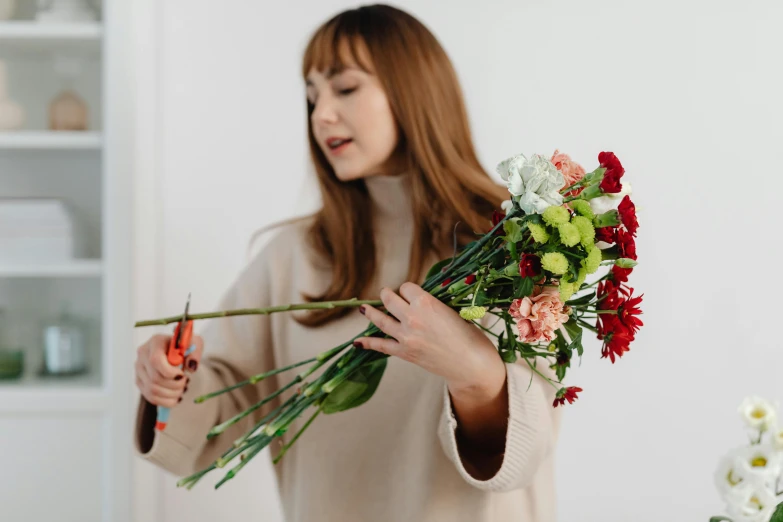 a woman holding a bouquet of roses while looking at her phone