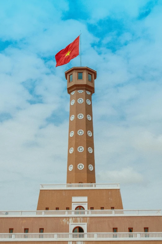 a brown and white building has a red flag