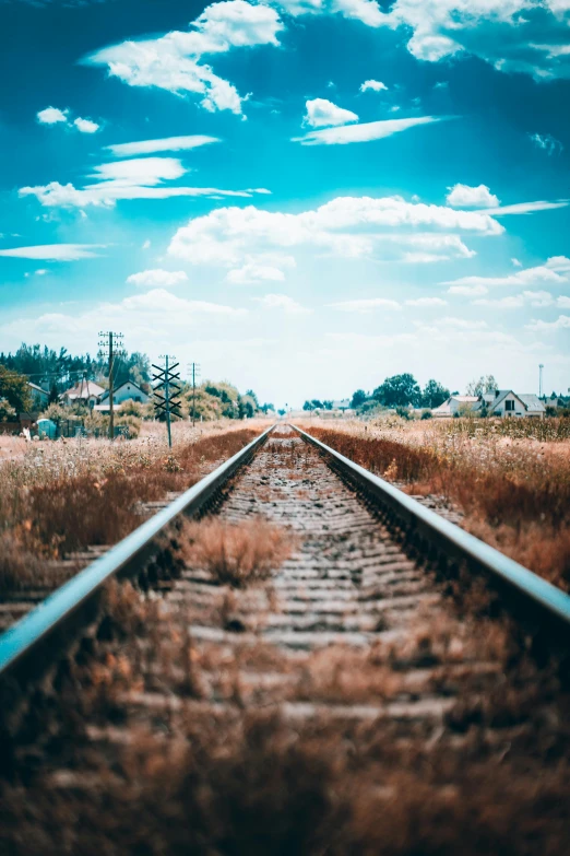 a railway runs on the top of grassy plains