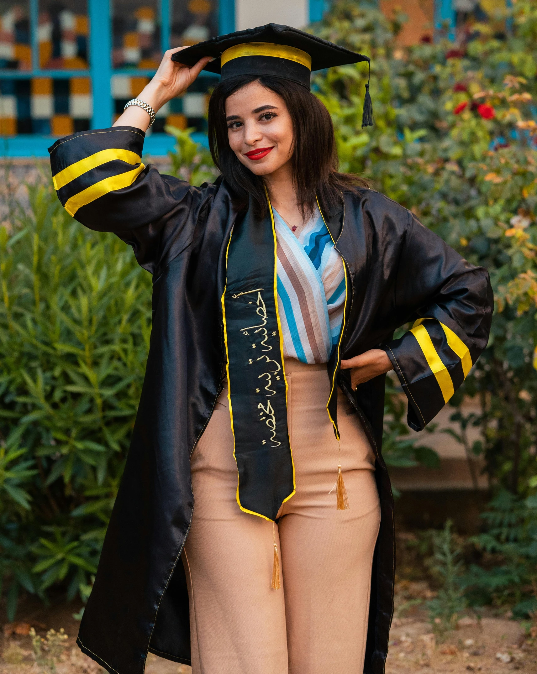 a woman in graduation gown and mortar hat posing for a po