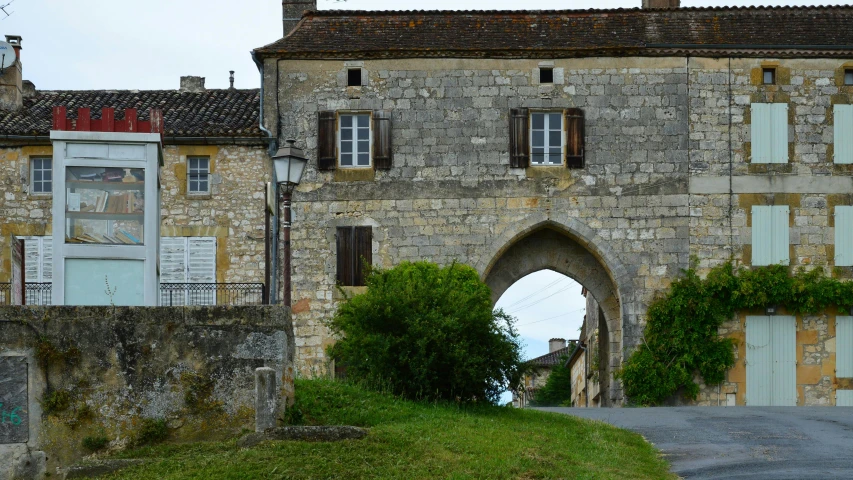 a cobblestone stone building with a small road underneath it