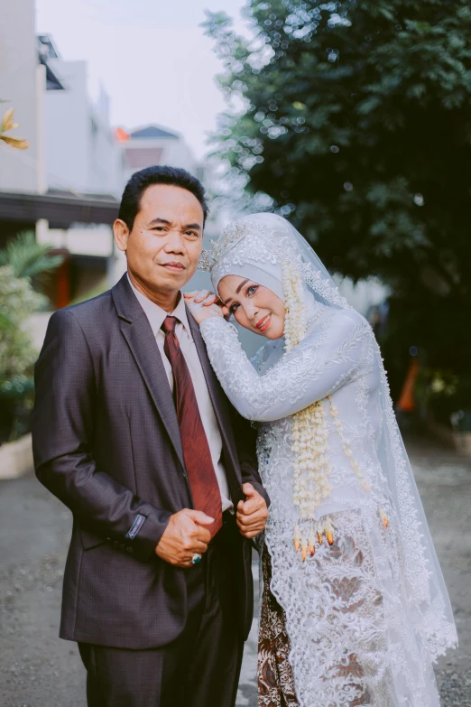 an asian bride and groom posing for a pograph