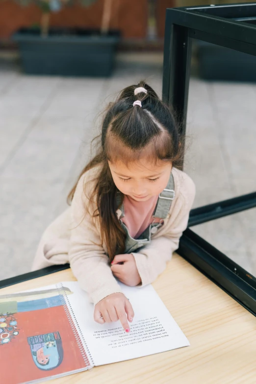 a little girl is sitting on the floor at a table