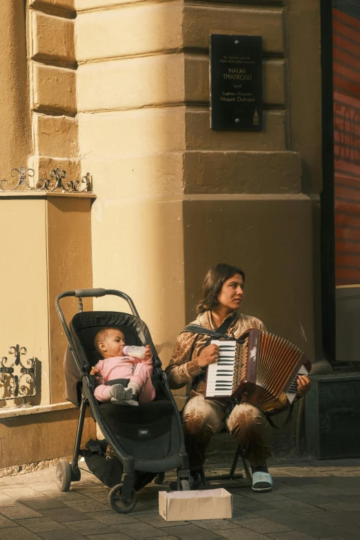 woman holding baby in stroller with musical device in hands