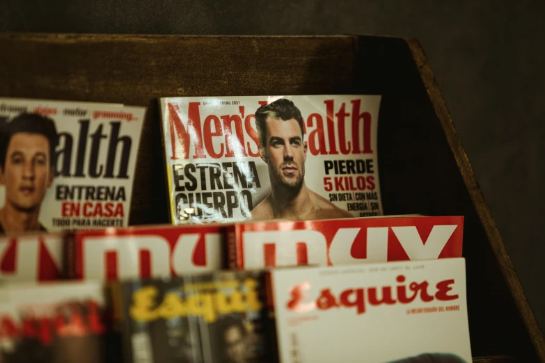 many magazines on display with pictures of men on them