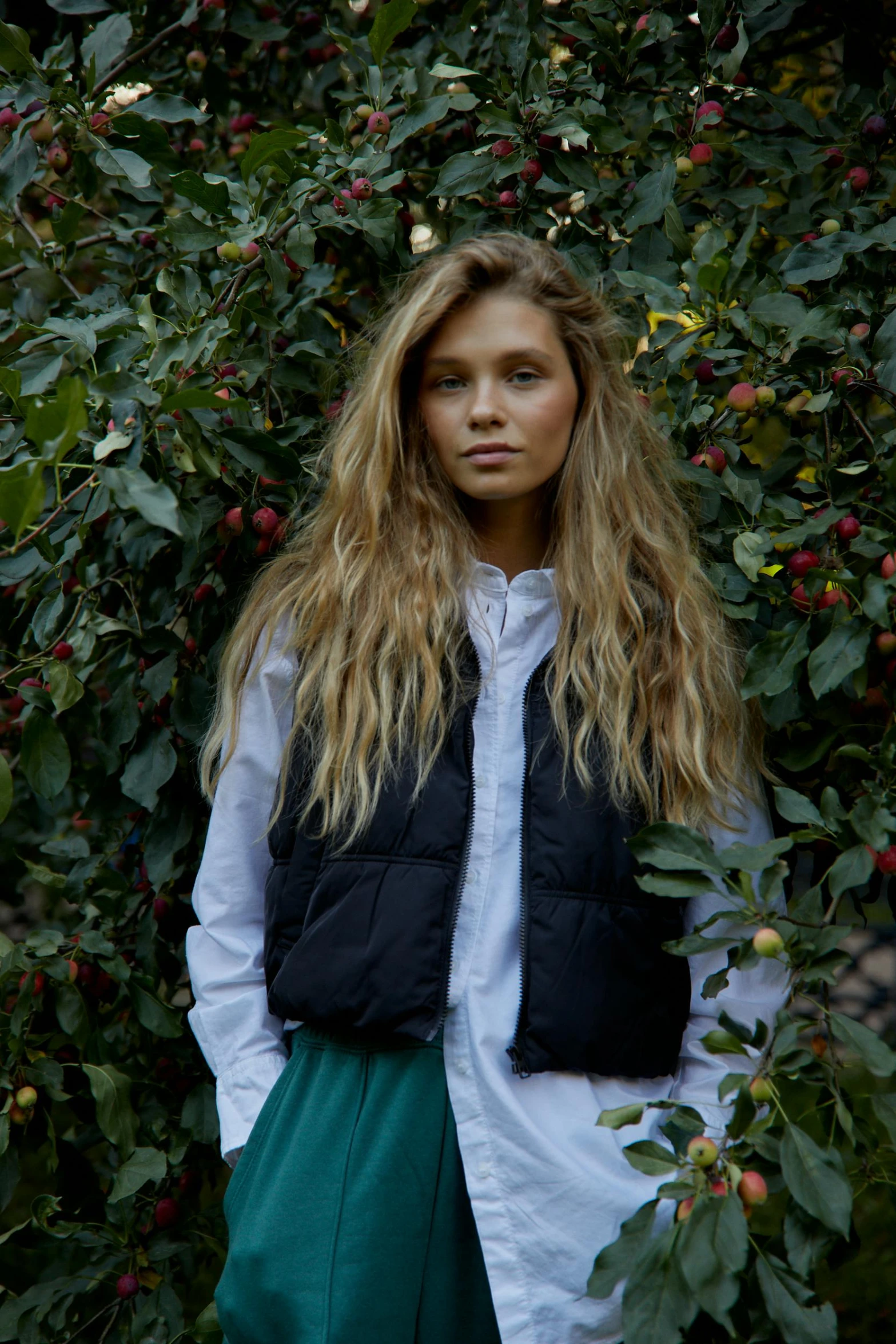 a girl standing in front of an apple tree