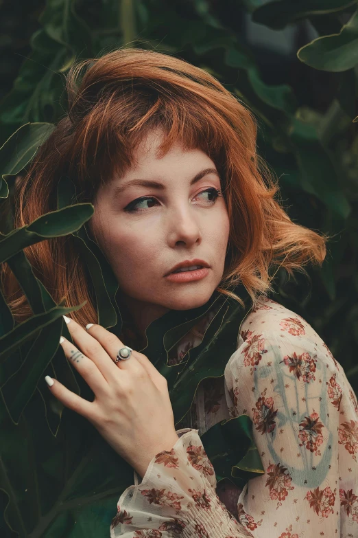 a woman with red hair is wearing a floral dress