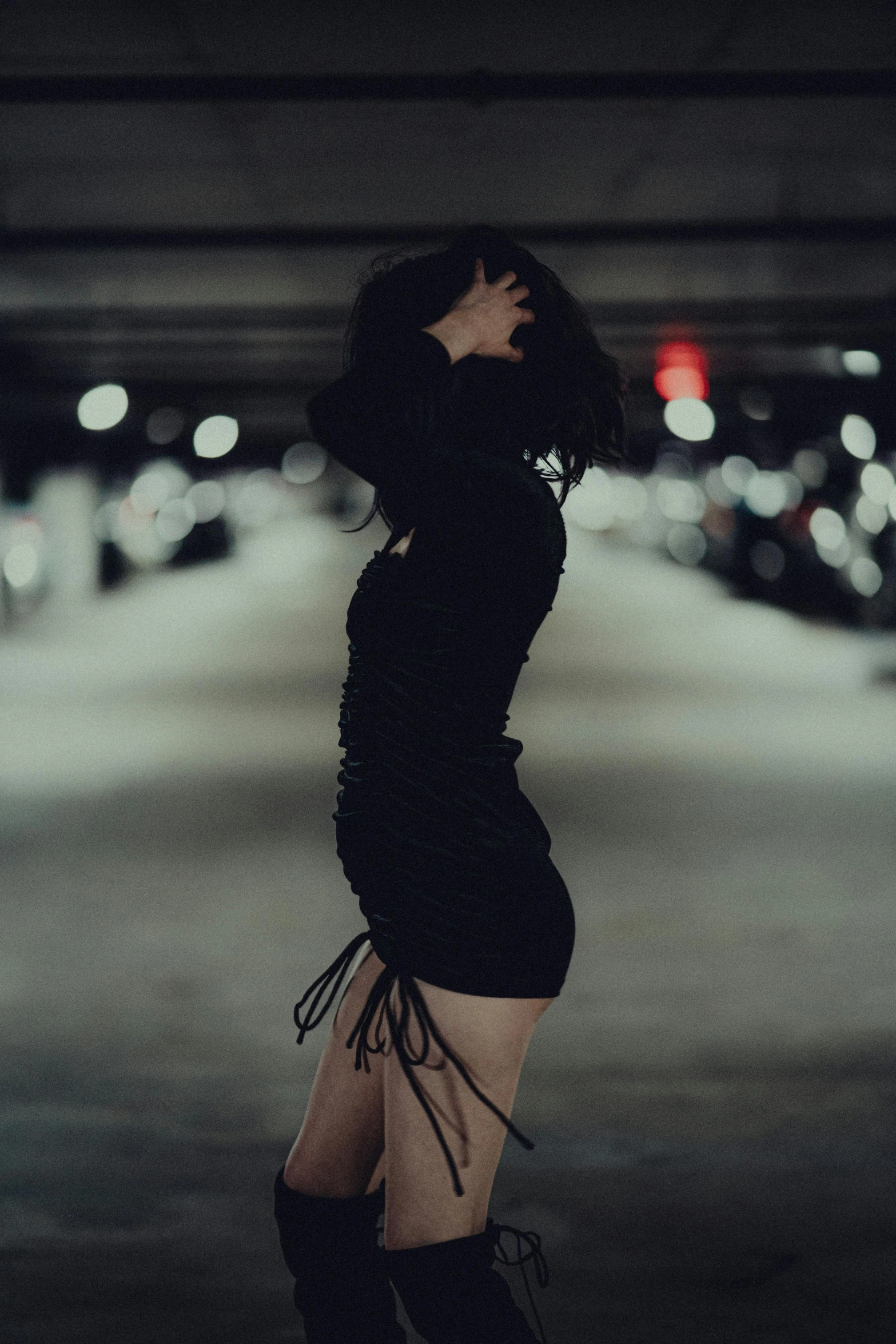 a woman in boots and a black sweater is standing outside